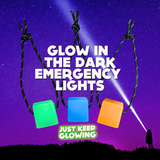 Three square glow in the dark emergency lights, one green, one blue, and one orange, hang by knotted black and white paracord against a deep blue backdrop with a bright beam of light and faint stars. The text "GLOW IN THE DARK EMERGENCY LIGHTS" is stacked in white above the lights, and "JUST KEEP GLOWING" is in a yellow box below. A silhouetted figure stands to the right, shining a light.