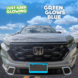 Blue glow in the dark license plate frame adding a unique and stylish touch to the front of a light-colored Honda CR-V. Just Keep Glowing.