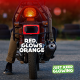 Red glow in the dark motorcycle license plate frame emitting an orange glow, enhancing visibility and adding a unique style to a motorcycle at night. Just Keep Glowing.