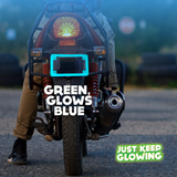 Green glow in the dark motorcycle license plate frame emitting a blue glow, enhancing visibility and adding a unique style to a motorcycle at night. Just Keep Glowing.